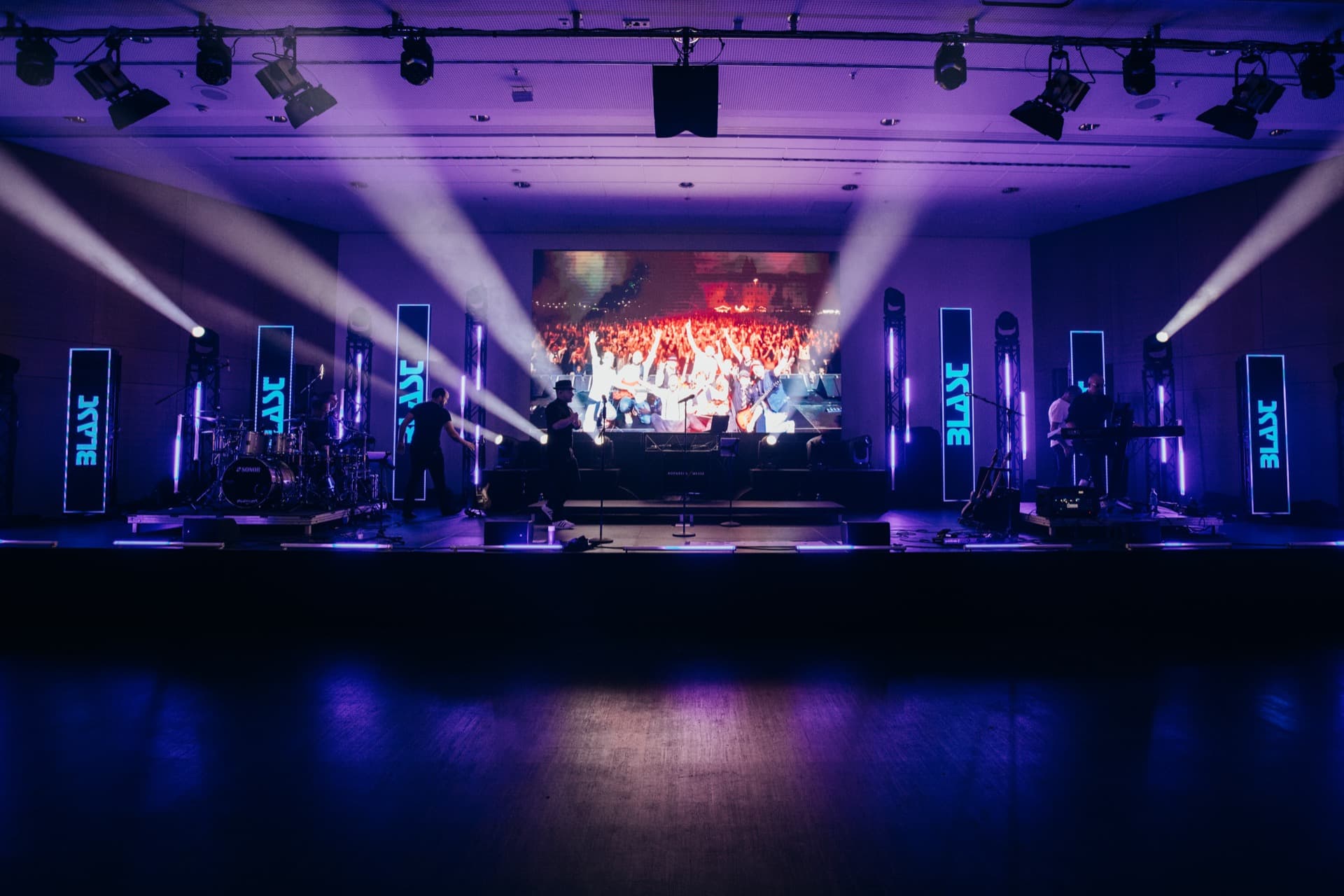 BLAST Bühnenproduktion mit lila-blauer Beleuchtung und LED-Säulen