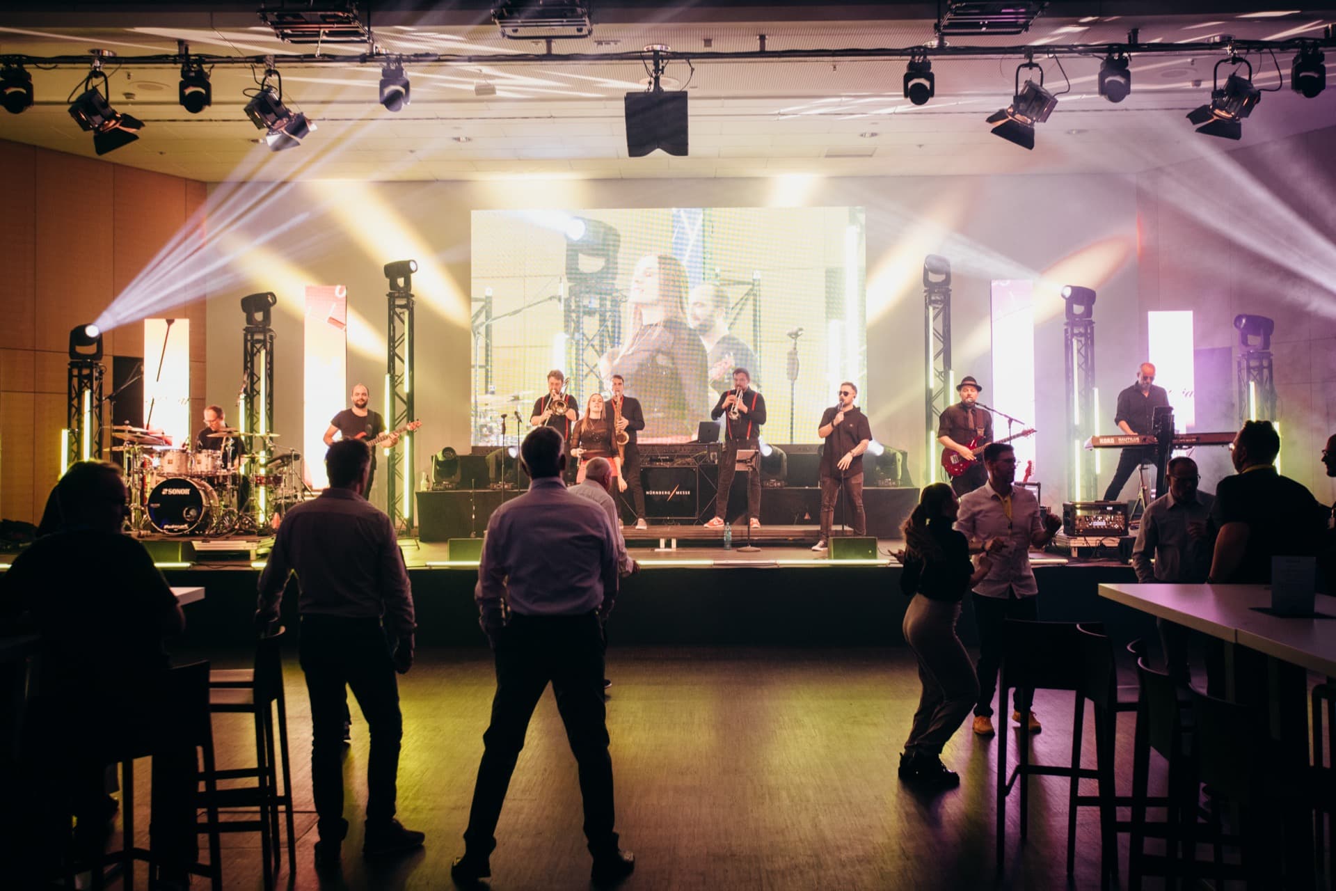 Firmen-Event mit Publikum an Tischen in warmem goldenen Licht
