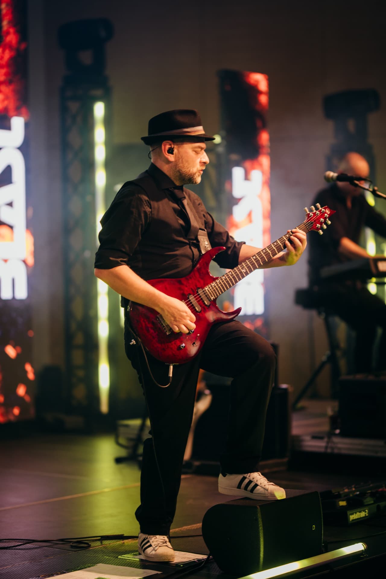 Gitarrist mit Hut und roter Gitarre
