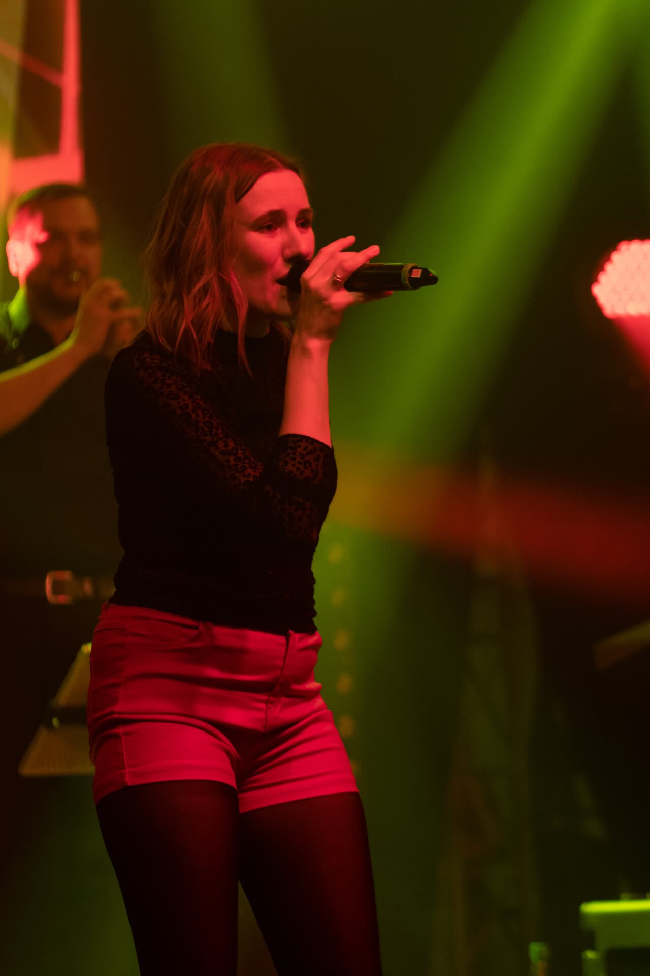 Sängerin performt in grün-rotem Licht