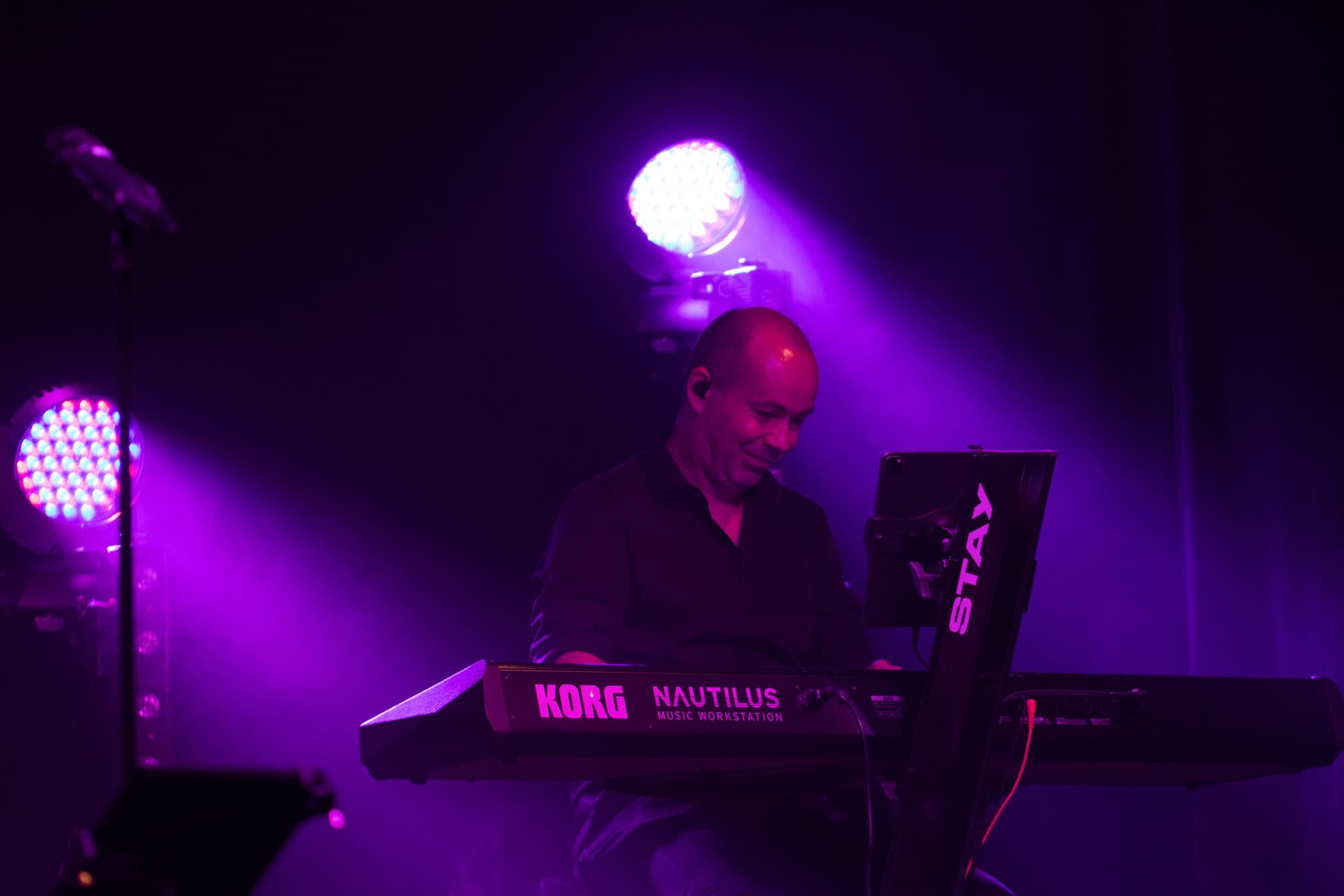 Keyboarder am KORG Nautilus in lila Beleuchtung