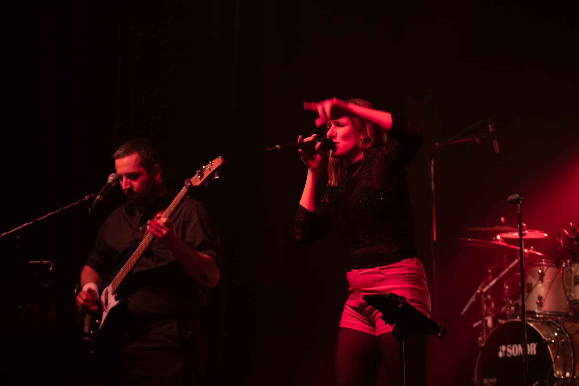 Bassist und Sängerin in roter Beleuchtung