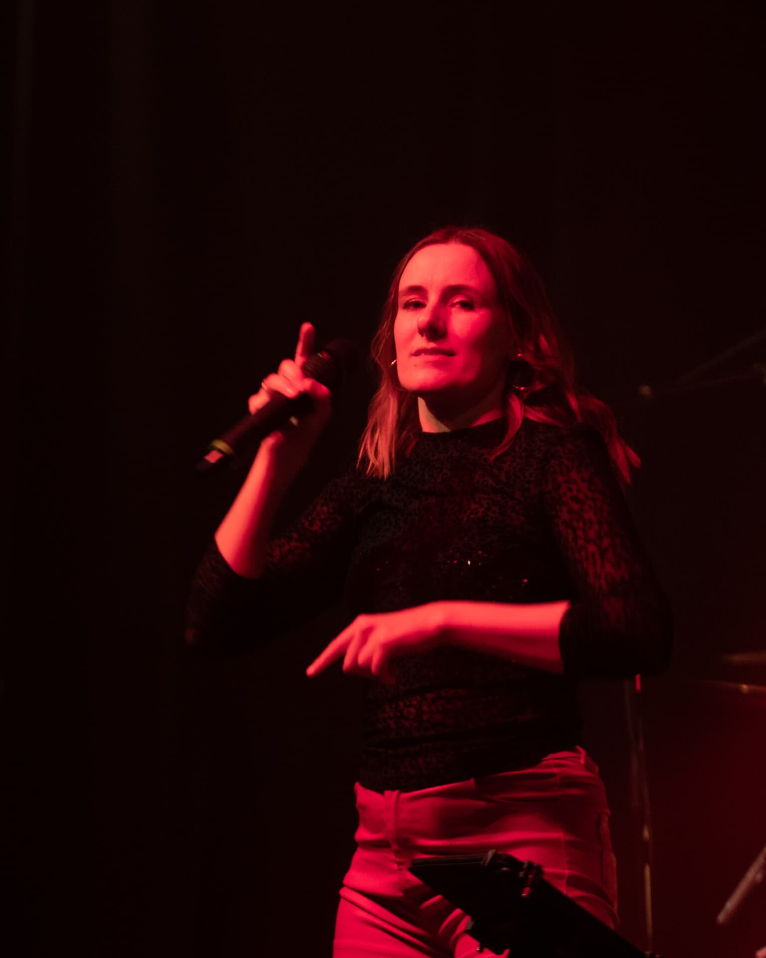 Sängerin mit Bassist in rot-bernsteinfarbenem Licht